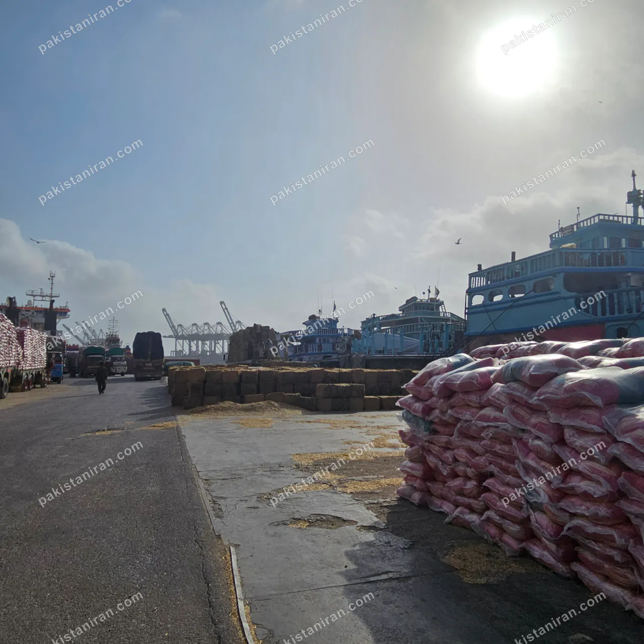 HAS Trading shipment: The working wharf: rice stacks, launches, and port cranes beyond